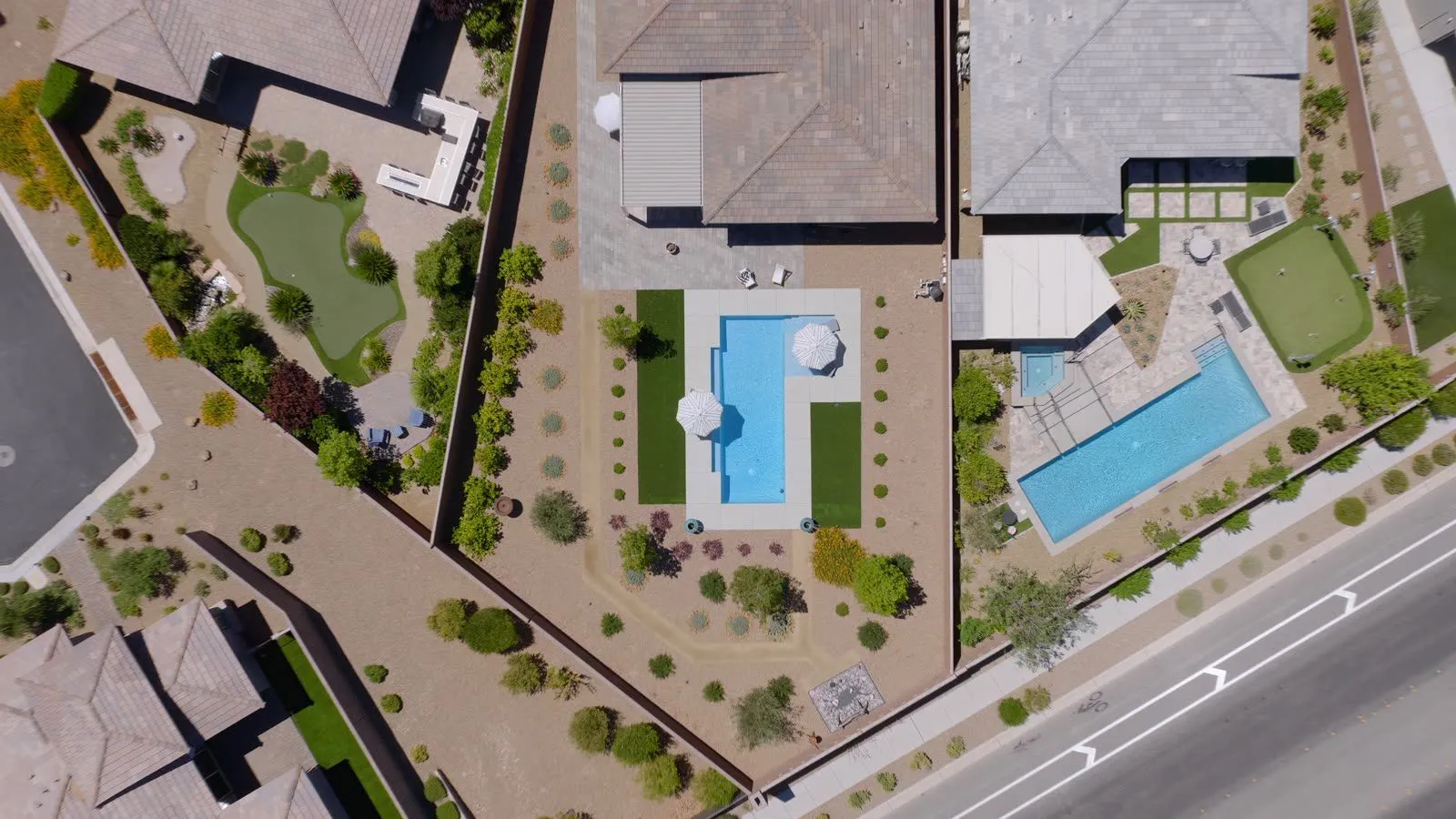 Aerial view of desert-landscaped Las Vegas backyards with swimming pools and putting greens