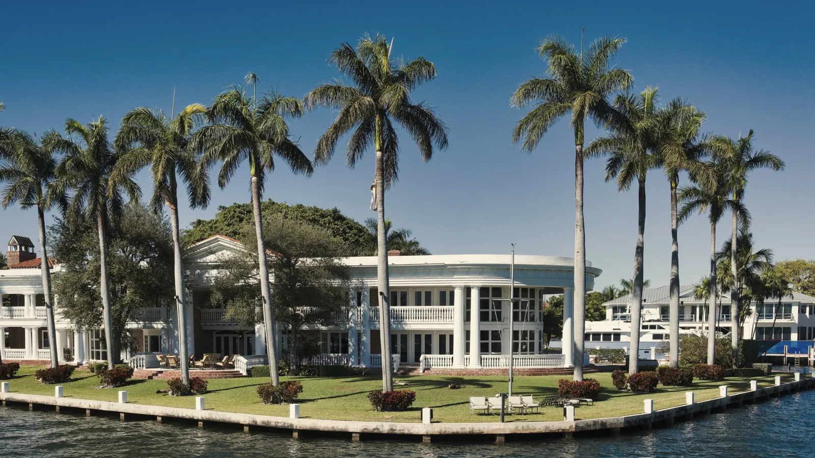 Waterfront home framed by palms