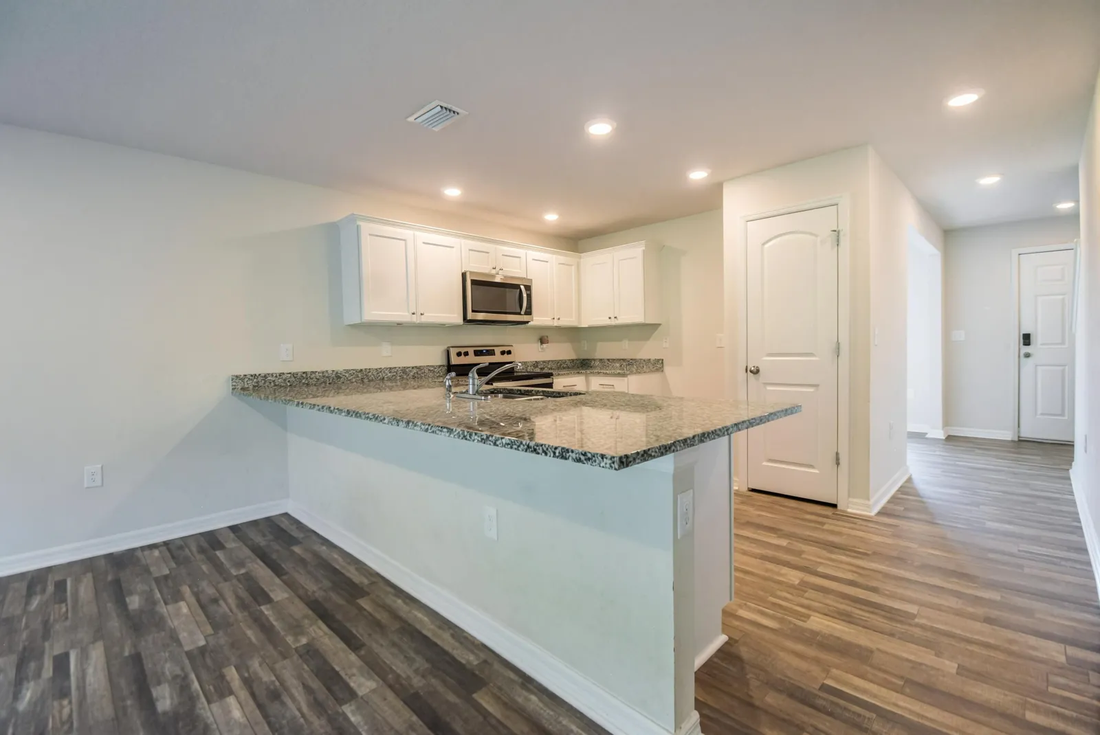 Kitchen with granite countertops and white shaker cabinets at 205 River Hill Drive