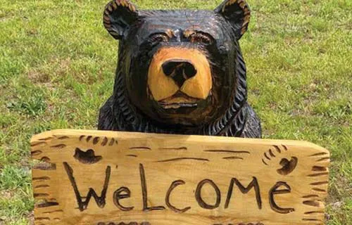 bear holding welcome sign