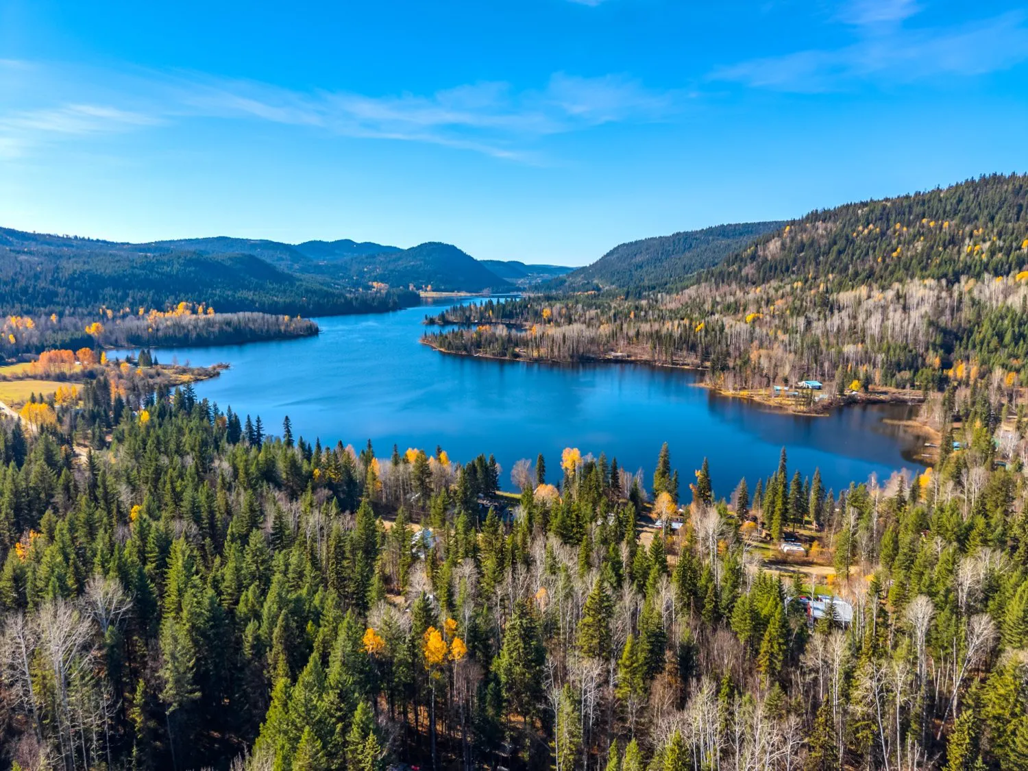 Aerial view of Hawkins Lake, wooded shoreline, scattered homes and autumn foliage