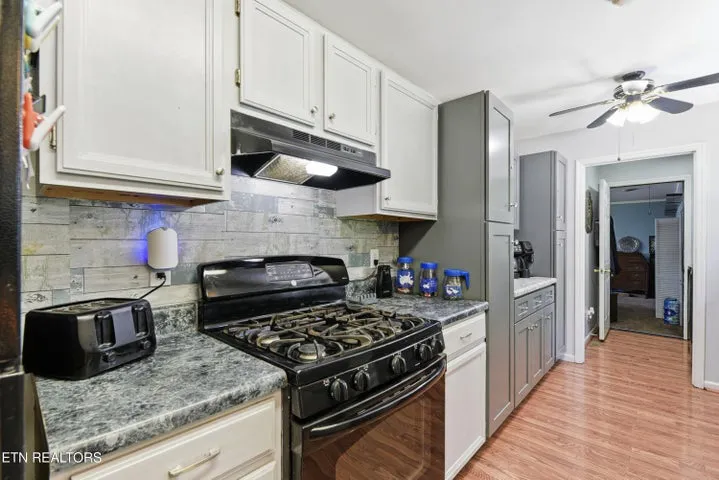 Kitchen with dark counters and white cabinetry