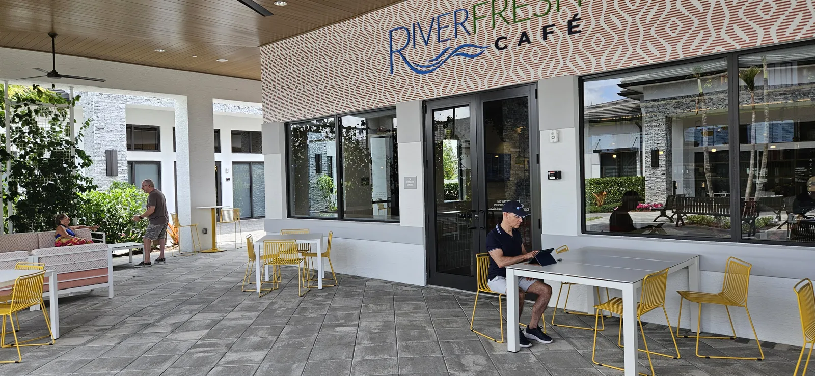 Thom Montrois working on his tablet during a beautiful day at the outdoor seating area of RiverFresh Cafe in Riverland, Port St. Lucie
